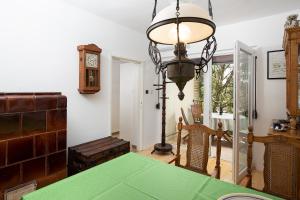 a dining room with a green table and a clock at Holiday Home Marko in Rebići