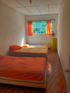 two twin beds in a room with a window at Chalet El Paraiso in Escuintla