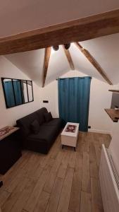 una sala de estar con un sofá y una mesa en Petit-cocon proche centre-ville, en Caluire-et-Cuire