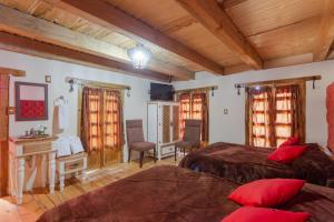 a bedroom with two beds and a desk and chairs at Hotel Boutique El Rincón in Zacatlán +51 photos