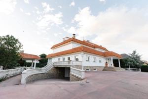 a white building with a red roof at La Casona Imperial in Alpedrete
