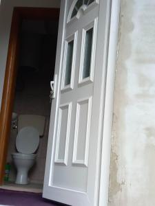 une porte blanche menant à une salle de bains avec toilettes. dans l'établissement Apartman Turkana 2, à Sarajevo