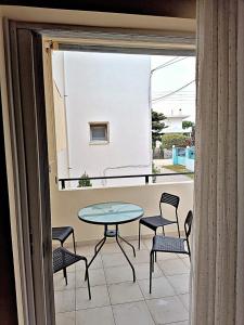 patio con mesa y sillas en el balcón en Evita, en Mitikas