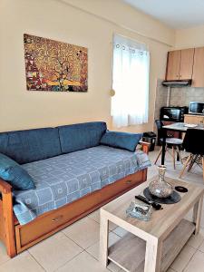 een woonkamer met een blauwe bank en een tafel bij Evita in Mitikas