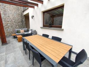 uma mesa de madeira e cadeiras num pátio em Fabula Home Rental - Casa Cuneo em Costa Volpino