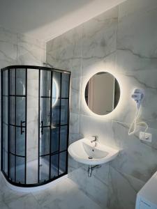 bagno con lavandino e specchio di Pine Apartments at San Pietro Resort a Durrës