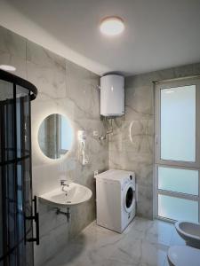 bagno con lavandino e lavatrice di Pine Apartments at San Pietro Resort a Durrës