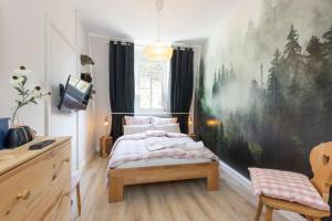 バート・エムスにあるFerienNest Haus Braunfelsのベッドルーム1室(ベッド1台付)が備わります。壁には絵画が飾られています。