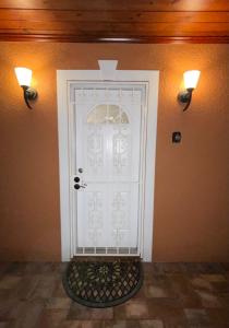 a white door with two lights on a wall at Twelve Oaks modern independent apartment in Tampa +7 photos