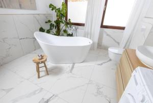een witte badkamer met een bad en een toilet bij Design & Relax #Altstadt #Sauna in Lutherstadt Wittenberg