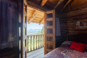 Un dormitorio con una cama y un balcón con vistas. en Hotel Boutique El Rincón, en Zacatlán