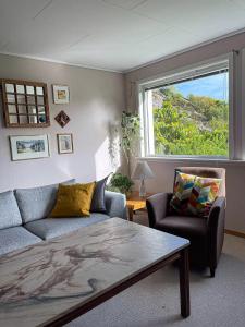 a living room with a couch and a window at Havgaarden, apt 1 in Stapnes