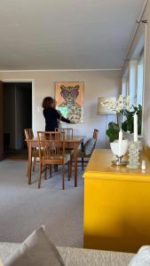 een vrouw aan een tafel in een woonkamer bij Havgaarden, apt 1 in Stapnes