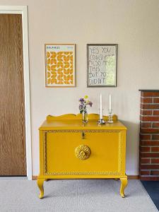 een gele tafel in een kamer met kaarsen erop bij Havgaarden, apt 1 in Stapnes
