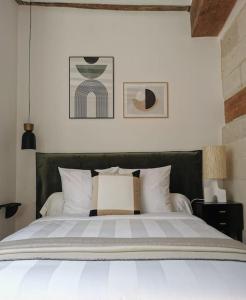 una camera da letto con un grande letto con cuscini bianchi di GUSTAVE - Quartier Historique a Nantes