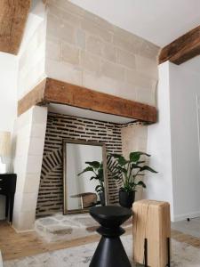 - un salon avec une cheminée en briques et un miroir dans l'établissement GUSTAVE - Quartier Historique, à Nantes