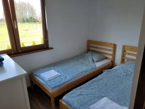 two twin beds in a room with a window at Domek letniskowy w Karwiku in Karwik