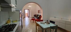 cocina con arco y mesa en una habitación en La casa in campagna, en Perdifumo