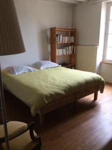 a bedroom with a bed and a book shelf at Chambres d'hôtes au calme 