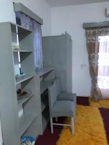 a white book shelf with a chair in a room at Tasos_Studios&Apartments 2 in Kranidi