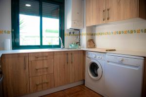 une cuisine avec un lave-linge et une fenêtre dans l'établissement Villa Arroyovil 25 y 30, à Mancha Real