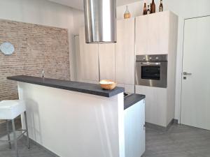 une cuisine avec des placards blancs et un comptoir dans l'établissement CASA MATTIA, à Livourne