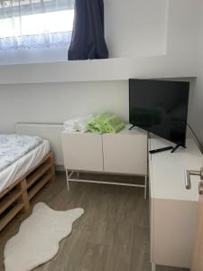a bedroom with a tv on a desk with a bed at Apartmán Ivona in Štípa