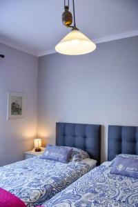 Un dormitorio con dos camas y una lámpara. en Bluehouse Paraiso á beira Mar, en São Vicente 41 fotos más