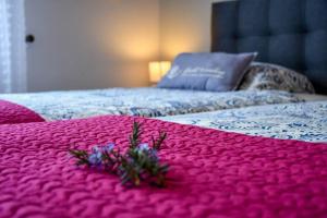 ein rosa Bett mit einer rosa Decke mit Blumen drauf in der Unterkunft Bluehouse Paradise Right by the Sea in São Vicente + 42 Fotos