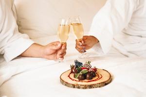 Due persone con bicchieri di champagne e un piatto di cibo di Four Points by Sheraton Santiago a Santiago