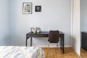 維勒班的住宿－Chambre privée dans appartement meublé.，卧室里一张带椅子的黑色书桌