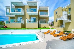 an apartment building with a swimming pool and chairs at Suites El Greco in Potos