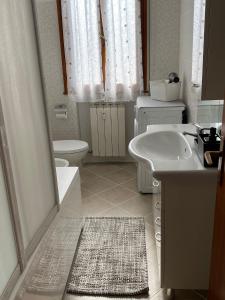 a white bathroom with a sink and a toilet at Casa Mattei in Chioggia +11 photos