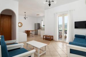 sala de estar con sillas azules y mesa en Almar Apartments en Batsi