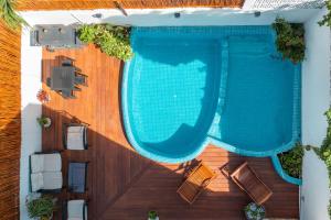 una terraza de madera con vistas a una piscina. en Villa Sofía Holiday Accommodation en Cancún