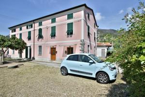 ein kleines Auto, das vor einem rosa Gebäude geparkt ist in der Unterkunft Alba & Tramonto in Levanto