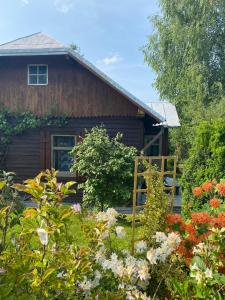 uma cabana de madeira com flores à frente em Domek „Na Górkach” em Grybów