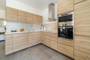 a kitchen with wooden cabinets and a stainless steel oven at Villa Janie - Luxury Multi-Level Estate with Pool in Supetar