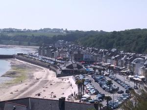 a beach with a bunch of parked cars and buildings at LA PORTE BLEUE in Cancale