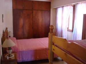 1 dormitorio con cama, armarios de madera y ventana en San Bernardo Frente Al Mar en San Bernardo