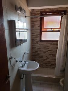 baño con lavabo y aseo y ventana en San Bernardo Frente Al Mar en San Bernardo