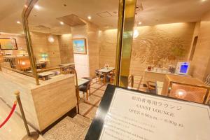 a restaurant with a sign in front of a dining room at New Osaka Hotel in Osaka