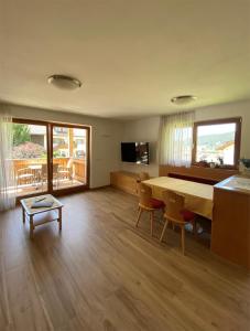 a large living room with a table and chairs at Apartments Stoll in Valle Di Casies