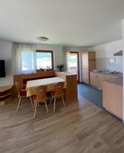 a kitchen and dining room with a table and chairs at Apartments Stoll in Valle Di Casies