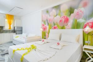 a bedroom with a white bed with pink flowers on the wall at Suites El Greco in Potos