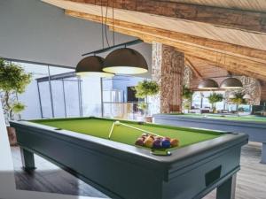 a pool table in the middle of a room at Wanderlust Experience Hotel in Campos do Jordão