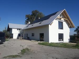 Agroturystyka BRYGADZIAKI في Charbielin: منزل أبيض مع لوحات شمسية على السطح