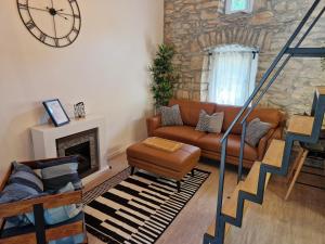 a living room with a couch and a clock on the wall at Casa della Noemi in Nedeščina