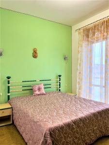1 dormitorio con 1 cama con edredón rosa y ventana en Casa MARINA, en Scalea