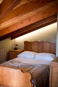 een slaapkamer met een groot houten bed met witte kussens bij Country style attic in the heart of Preveza in Preveza
